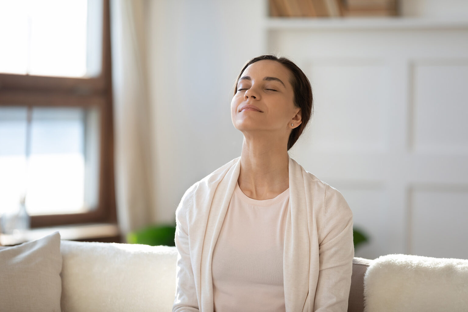 Meditaatio muuttaa aivoja - Nainen meditoimassa sohvalla